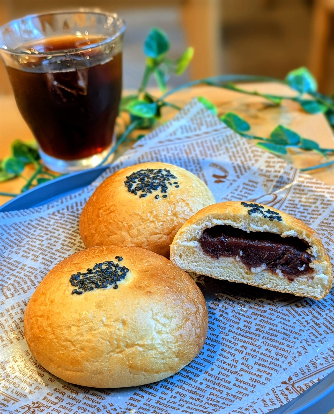 黒ごまを飾った焼きたてあんぱんとアイスコーヒー